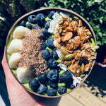 Maple Cinnamon granola served on a power greens smoothie bowl with fruit, coconut and ground flax