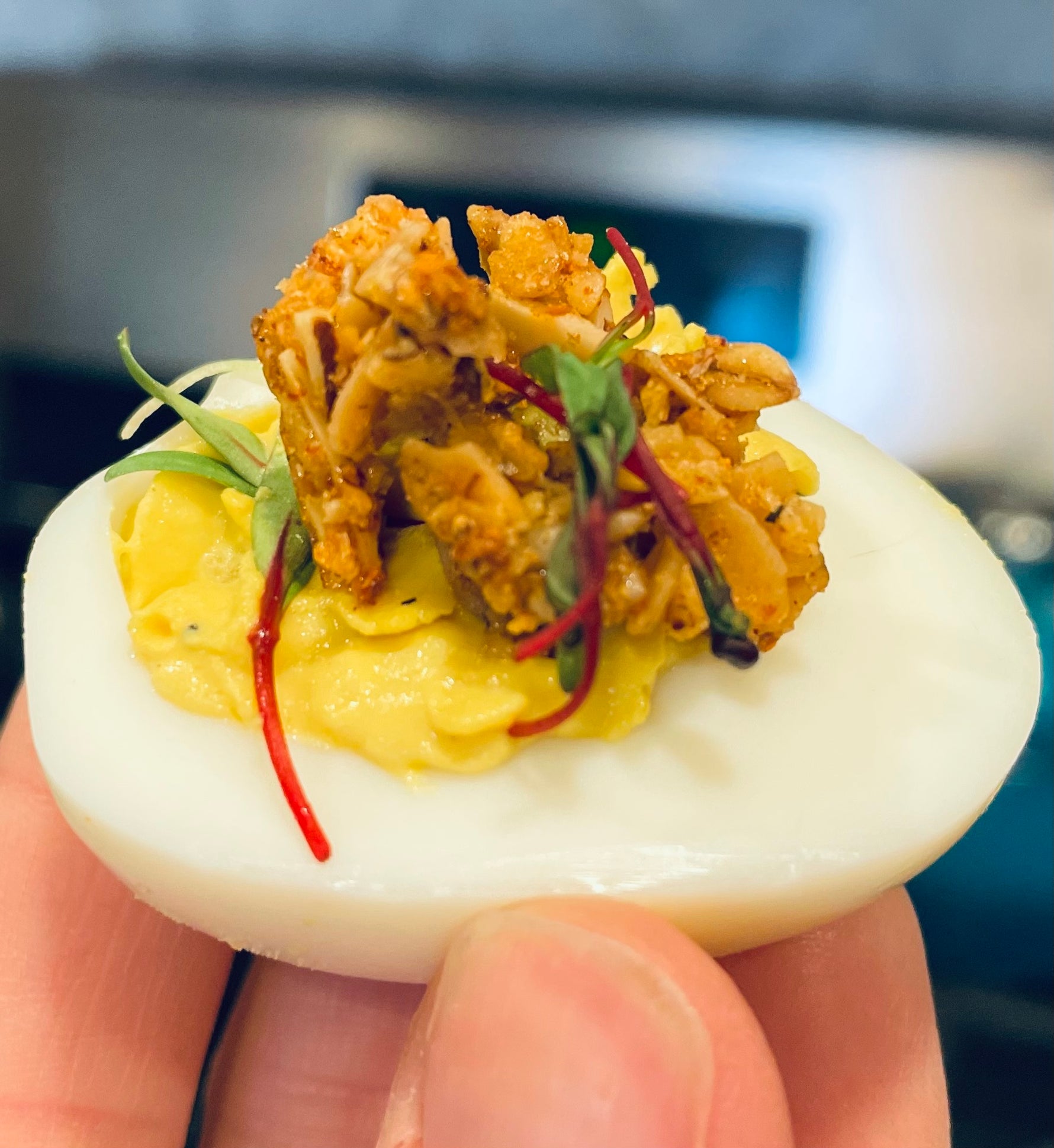 Savory granola served on deviled egg with microgreens